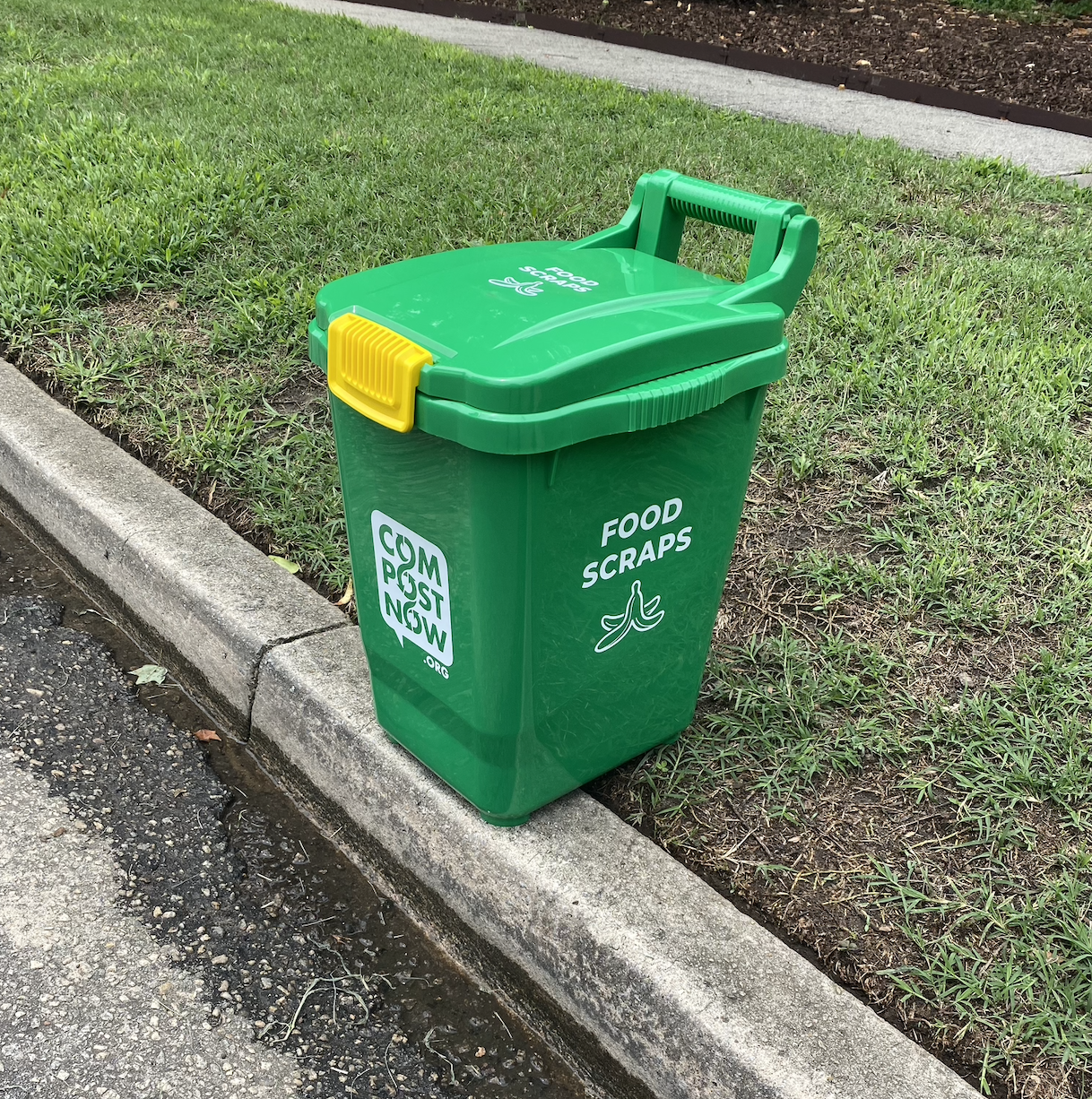 CompostNow green compost bin at the curb for pickup